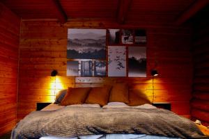 1 dormitorio con 1 cama en una pared de madera en Kätkä Lake Lodge, en Tervola