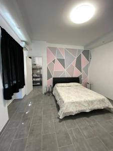 1 dormitorio con cama y pared rosa y gris en Dbe apartment LA SIRENA, en Francavilla al Mare