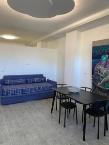 a living room with a couch and a table and chairs at Dbe apartment LA SIRENA in Francavilla al Mare