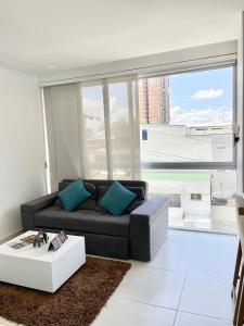 sala de estar con sofá y ventana grande en Apartamentos Loft Mikonos, en Pereira