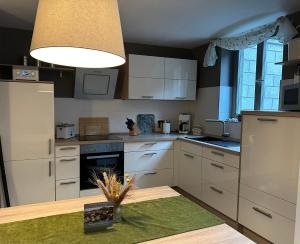 uma cozinha com electrodomésticos brancos e uma mesa em Monopol Apartments em Wernigerode