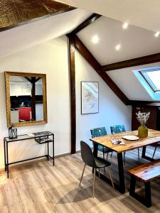 a dining room with a table and a mirror at LE CHAMPENOIS, Avenue de Champagne in Épernay
