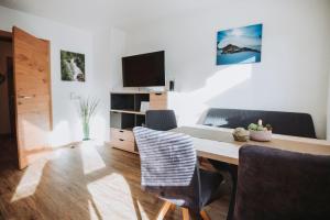 a living room with a table and chairs and a television at Appartement Stern Dagmar in Neustift im Stubaital