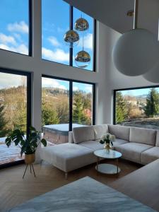sala de estar con sofá blanco y ventanas grandes en Black Diamonds Hill en Istebna
