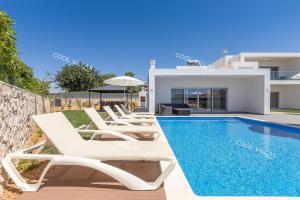 a villa with a swimming pool and a house at Villa Alfazema - heatable pool in Albufeira