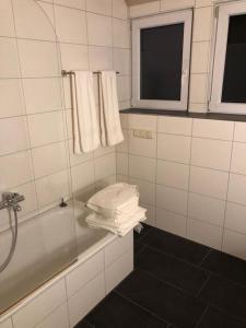 a bathroom with a tub and a window and towels at Superschöne Ferienwohnungen! in Buxheim