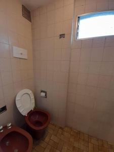 een badkamer met een rood toilet en een raam bij Mar del plata in Mar del Plata