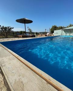 uma grande piscina com um guarda-sol ao lado em Zenstay Hotel em Áyios Nikólaos Nirás