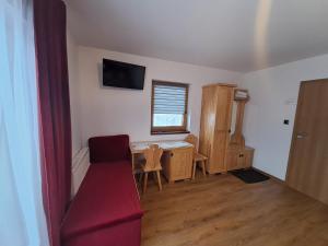 a room with a desk and a window and a red couch at Willa Grand Krzesanica in Kościelisko