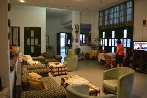 a living room with couches and chairs and a television at Hotel Finiki View in Foiníkion