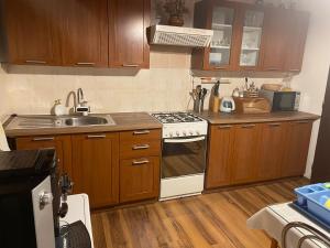 a kitchen with wooden cabinets and a stove top oven at Privát Martin in Martin