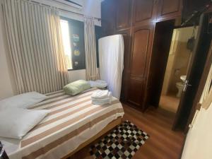 Habitación pequeña con cama y baño. en Hotel Nelly, en São Gabriel