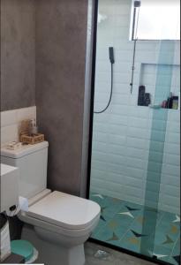 a bathroom with a toilet and a glass shower at CASA AZUL São Pedro in São Pedro