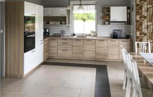 una cucina con mobili bianchi, un lavandino e un tavolo di Stunning Home In Grabowska Huta a Nowa Karczma