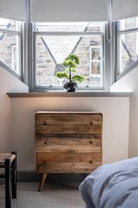 a bedroom with a wooden dresser and a window at The Arran, St Andrews in St. Andrews