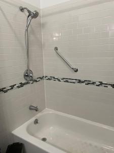 a white bath tub in a bathroom with a shower at Wonderful 2 Bedroom in the heart of Astoria in Steinway