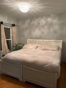 a white bed in a room with a window at Wonderful 2 Bedroom in the heart of Astoria in Steinway