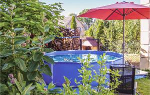 a hot tub in a garden with an umbrella at Amazing Home In Darlowo With Outdoor Swimming Pool in Darłowo