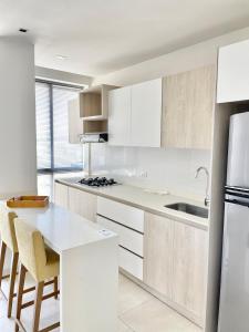 cocina con armarios blancos y encimera blanca en Apartamentos Loft Mikonos, en Pereira