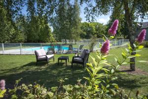 un patio con sillas y una piscina en The Originals City, Hôtel La Saulaie, Saumur Ouest (Inter-Hotel) en Doué-la-Fontaine