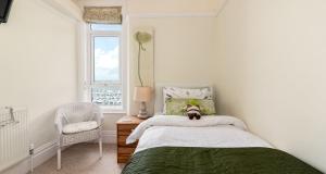 a dog laying on a bed in a bedroom at Marina View Brixham in Brixham