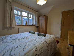a bedroom with a large bed and a window at Unbeatable Llanberis Location, Detached with Parking, Snowdon Views. in Llanberis