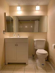 a bathroom with a toilet and a sink and a mirror at MT Pleasant NW 2 bedrooms 502 in Calgary +15 photos