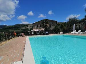 a large blue swimming pool in front of a building at CASALE SAN FORTUNATO in Spello