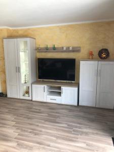 a living room with a flat screen tv and white cabinets at Ferienwohnung Dunja in Bullay