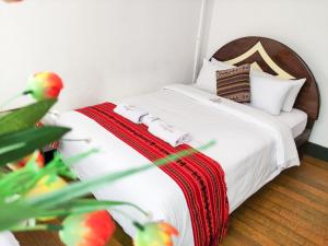 1 dormitorio con cama blanca y cabecero de madera en Hostal Cusco Internacional, en Cusco