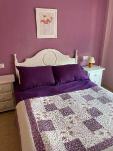 una camera con letto e pareti viola di APARTAMENTO PALMERAL DEL MAR MENOR a Los Nietos