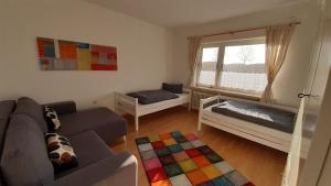 a living room with a couch and a window at Ferienhaus Großheider Straße in Großheide