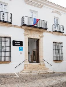 a white building with a rainbow flag on the balcony at Hotel Tugasa Casa Palacio Medina Sidonia in Medina Sidonia