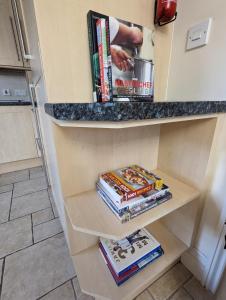 a book shelf in a kitchen with books at Unbeatable Llanberis Location, Detached with Parking, Snowdon Views. in Llanberis