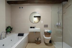 的住宿－casa rural mara mara，带浴缸、水槽和镜子的浴室