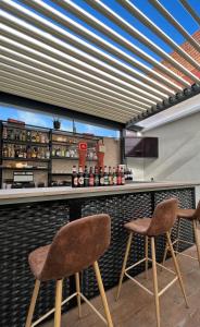 eine Bar mit zwei Stühlen an einer Theke in der Unterkunft Hotel Duero in Laguna de Duero