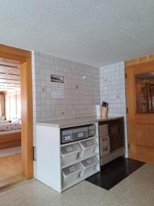 uma cozinha com um balcão com electrodomésticos e uma sala em Haus Annelies em Bizau
