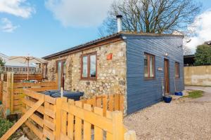 a blue tiny house with a wooden fence at The Croft @ Warrens Farm in Taunton