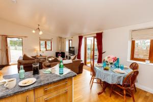 a kitchen and living room with a table and chairs at The Croft @ Warrens Farm in Taunton