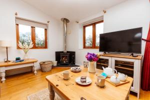 a living room with a table and a fireplace at The Croft @ Warrens Farm in Taunton