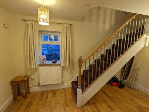 a staircase in a living room with a window at Unbeatable Llanberis Location, Detached with Parking, Snowdon Views. in Llanberis
