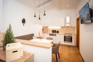a kitchen with white cabinets and a table and chairs at Kuckuck Hinterthal - Appartements in Hinterthal