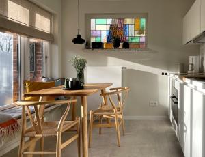 eine Küche mit einem Tisch und Stühlen sowie einem Buntglasfenster in der Unterkunft Ferienwohnung Klaus in Wyk auf Föhr