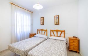two twin beds in a room with a window at Beautiful Apartment In Santa Pola in Santa Pola +8 photos