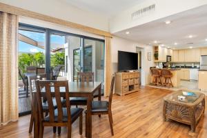 een keuken en een woonkamer met een tafel en stoelen bij Big Island Royal Sea Cliff 401 condo in Kailua-Kona