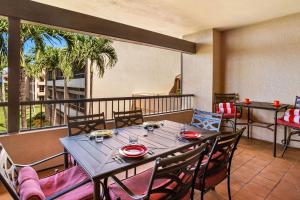 a dining room with a table and chairs on a balcony at Kaanapali Royal G303 condo in Lahaina