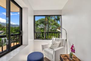 sala de estar con silla, mesa y ventana en Kaanapali Royal G303 condo, en Lahaina