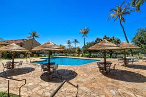 a pool with tables and chairs and umbrellas at Kaanapali Royal G303 condo in Lahaina