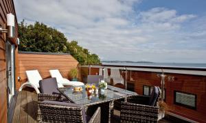 a patio with a table and chairs on a balcony at Plover 2 - The Cove in Brixham
