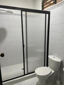 a bathroom with a toilet and a shower stall at Tu hogar en Cali Apto centrico cómodo y privado in Cali
